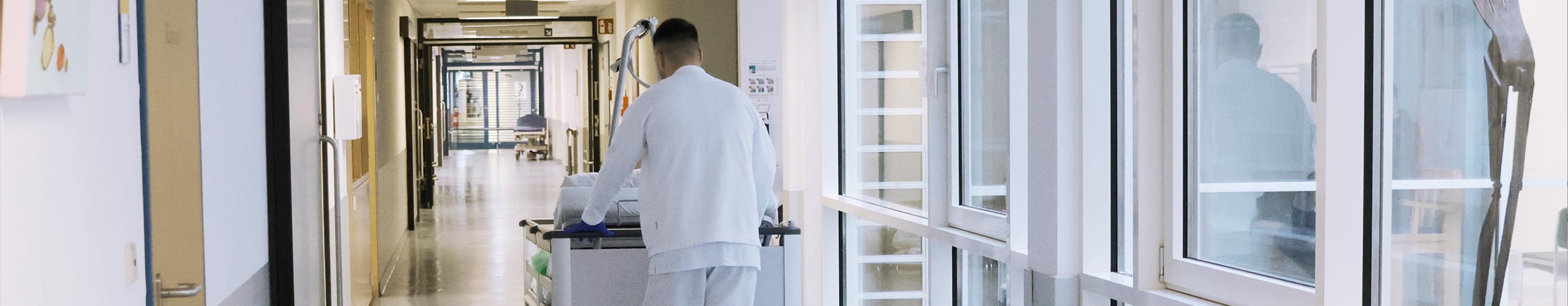 Dekobild Patient wird durch Flur im Bett geschoben