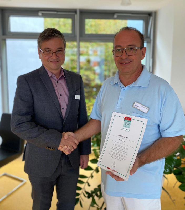 Harald Löffler (links) gratuliert dem Leiter des Therapeutenpools an den Standorten Buchen und Mosbach der Neckar-Odenwald-Kliniken Andreas Parzer (rechts) zur besonderen Auszeichnung. 