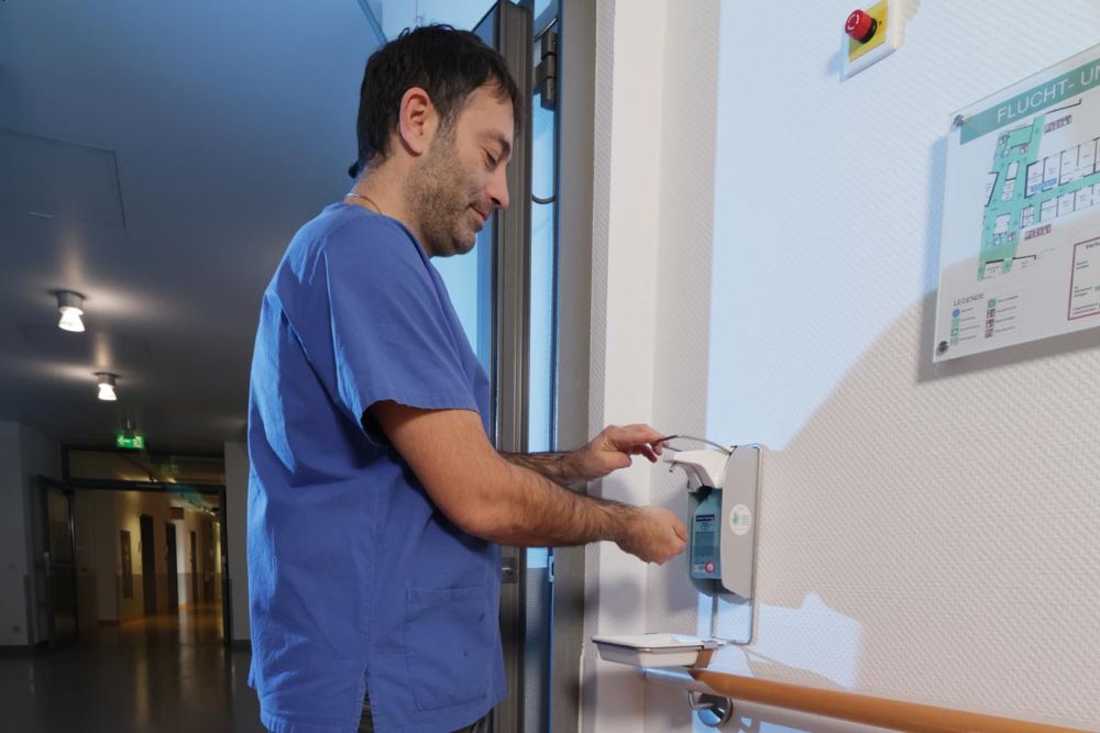 Mann desinfiziert sich seine Hände