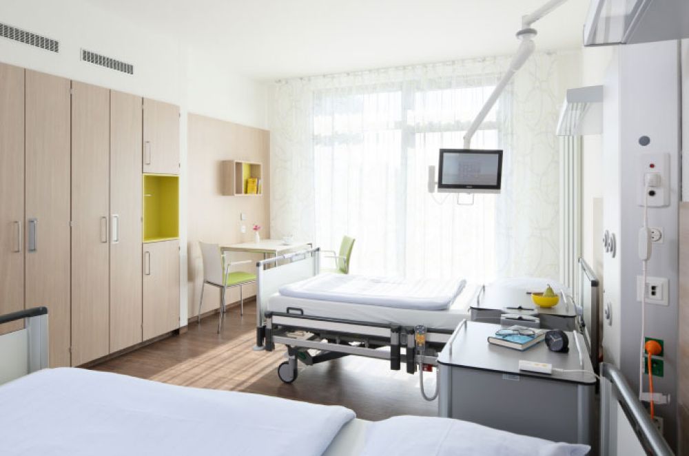 Krankenhauszimmer mit Betten und vielen Schränken
